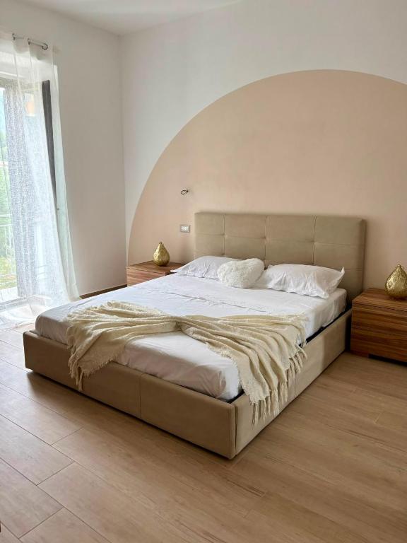 a large bed in a bedroom with a large arch above it at B&B Realis Terme in Montagnola