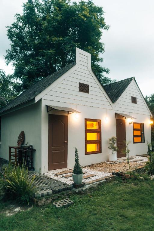 a small white house with a tree in the yard at Always Boutique Stay 2 in Kampong Huaibū