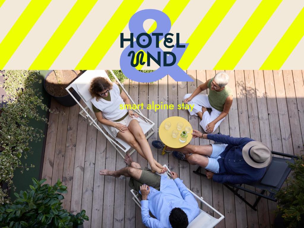 a group of people sitting on a chair on a patio at Hotel UND - smart alpine stay in Schladming