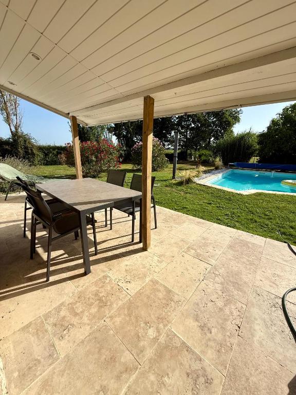 a patio with a table and chairs under a pavilion at La Prairie 65 in Lafitole