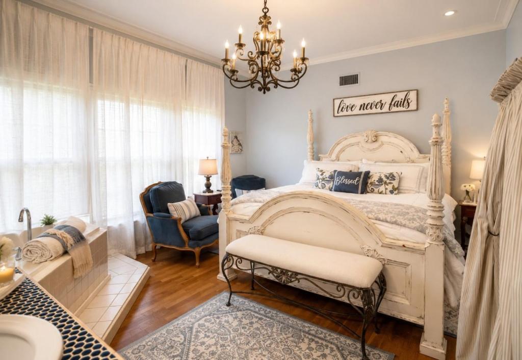 a bedroom with a large white bed and a chandelier at Historic Mansion-King Suite-The Blue Jay in Fort Smith