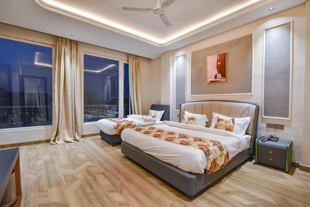 a bedroom with two beds and a large window at HOTEL La VILLA in Amritsar