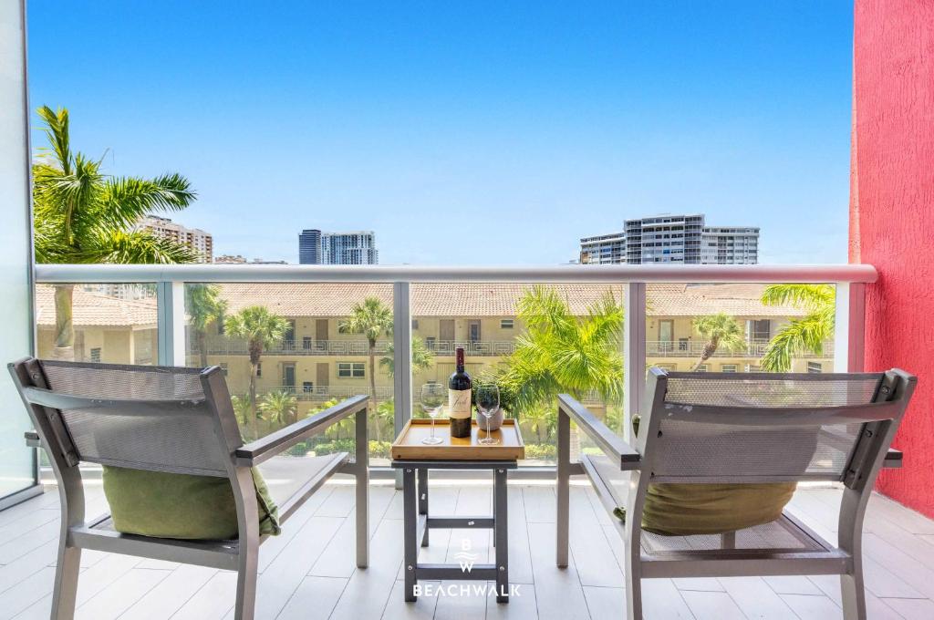 a balcony with two chairs and a table with a bottle of wine at Pininfarina Studio Intracoastal View in Hallandale Beach