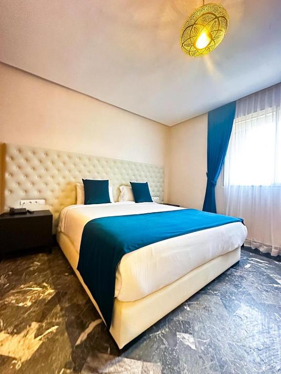 a bedroom with a large bed with a blue blanket at Villa zitoun in Aït Bou Zguia
