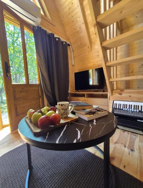 ein Tisch mit einem Tablett mit Früchten darauf in einer Hütte in der Unterkunft Tiny House 4-Imanje Terzic in Golubovci