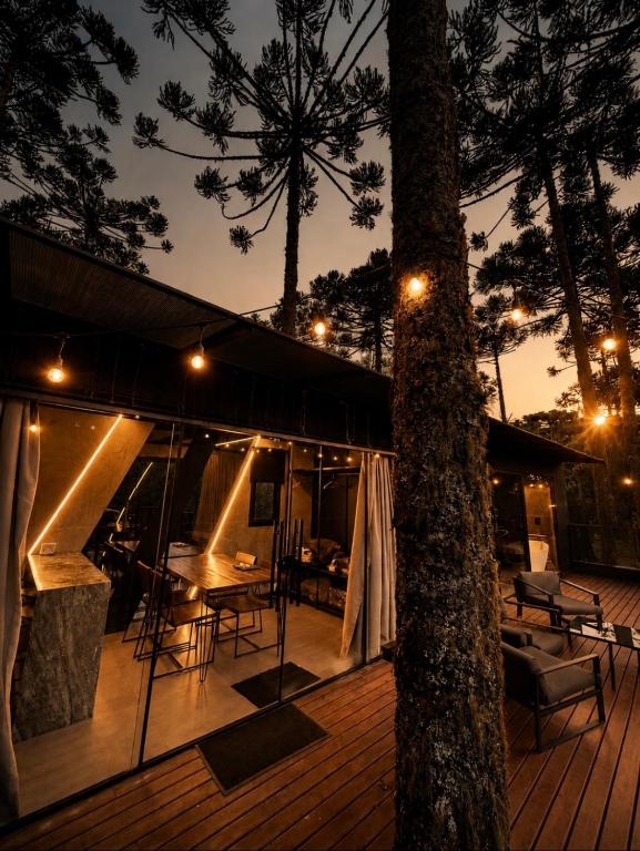 a wooden deck with a table and chairs and a tree at Forte das Araucarias in Urubici