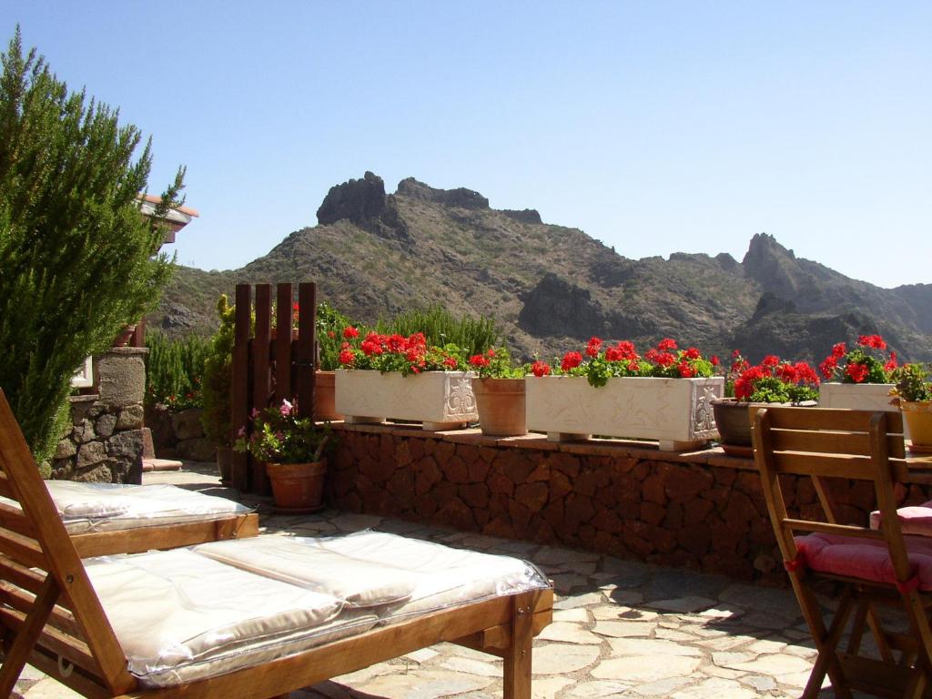 a patio with flowers in pots on a wall at Casa Rural Las Piedras in Buenavista del Norte