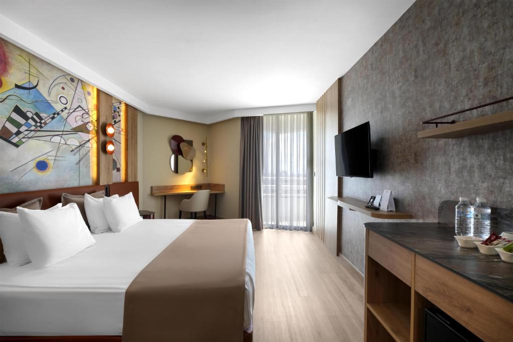 a hotel room with a large bed and a television at Best Western Plus Khan Hotel in Antalya