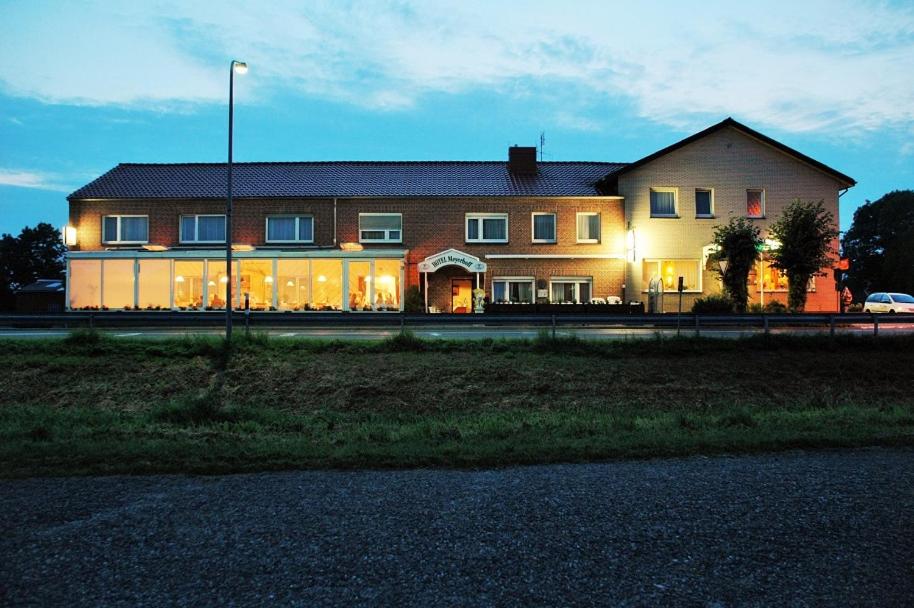 a large house is lit up at night at Hotel Meyerhoff in Ostrhauderfehn