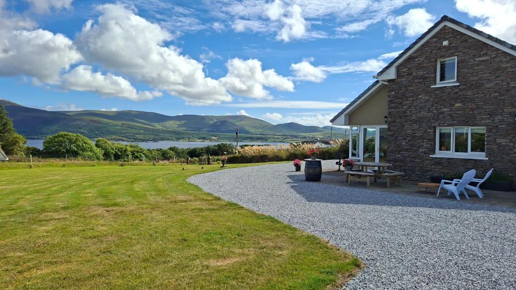 a stone house with a picnic table and a bench at B&B Kerry Lakesview Lodge in Waterville