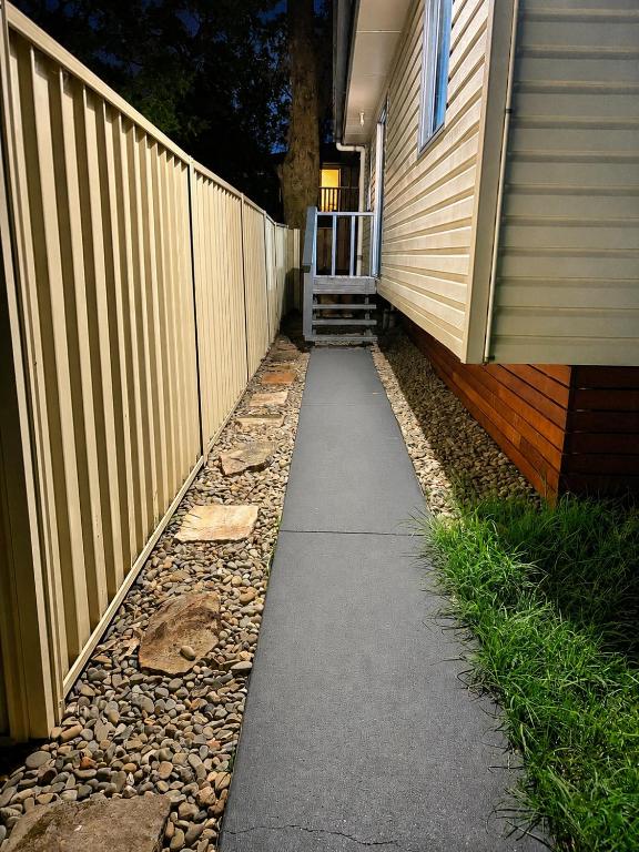 a sidewalk next to a fence next to a house at 21A Armstrong Place in Schofields