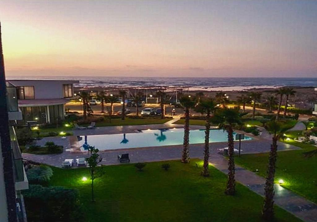 an aerial view of a resort with a pool and palm trees at Charmant Appartement avec une vue imprenable in Tamaris