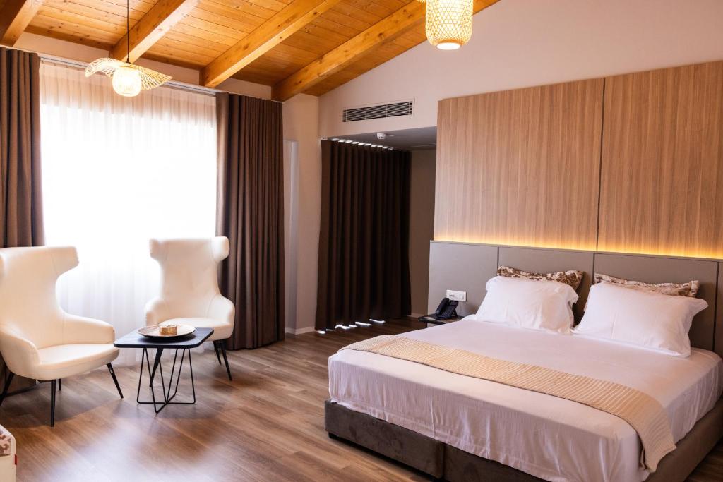 a bedroom with a bed and a table and chairs at KAÑ Inn in Vlorë