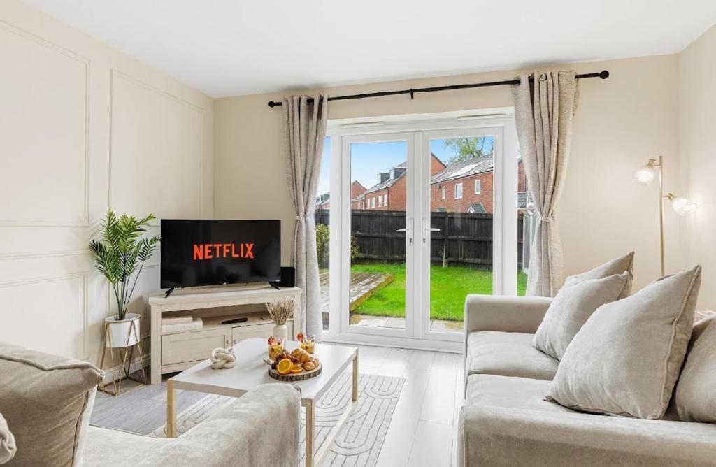 a living room with a couch and a tv at Home Comforts Await! 3bed 2.5bath in Ellesmere Port