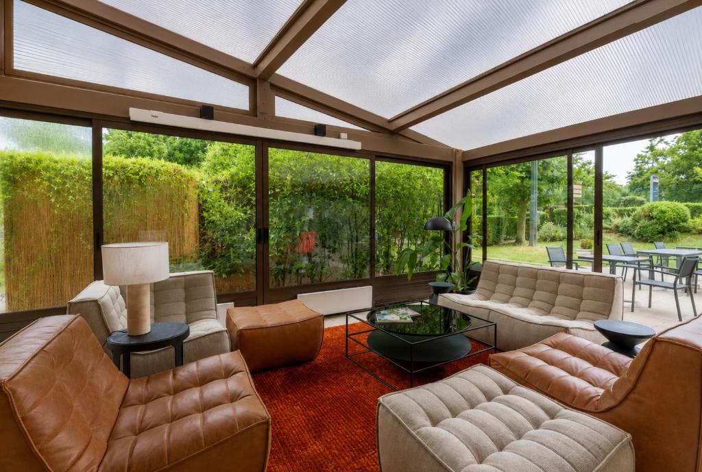a living room filled with furniture and a large window at Campanile Reims Sud Bezannes in Reims