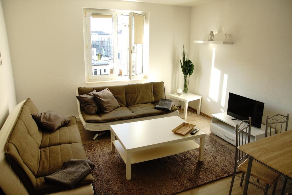 ein Wohnzimmer mit einem Sofa und einem Tisch in der Unterkunft FEWO Leipzig-Plagwitz in Leipzig
