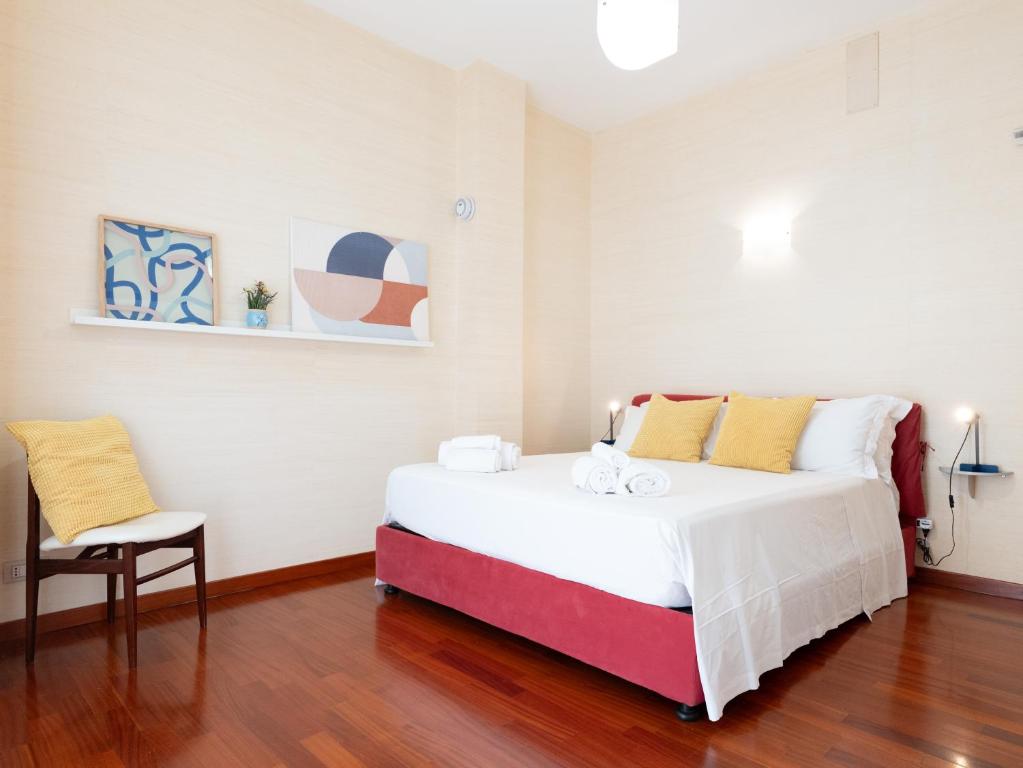 a bedroom with a large white bed and a chair at Dadu 150 in Bari