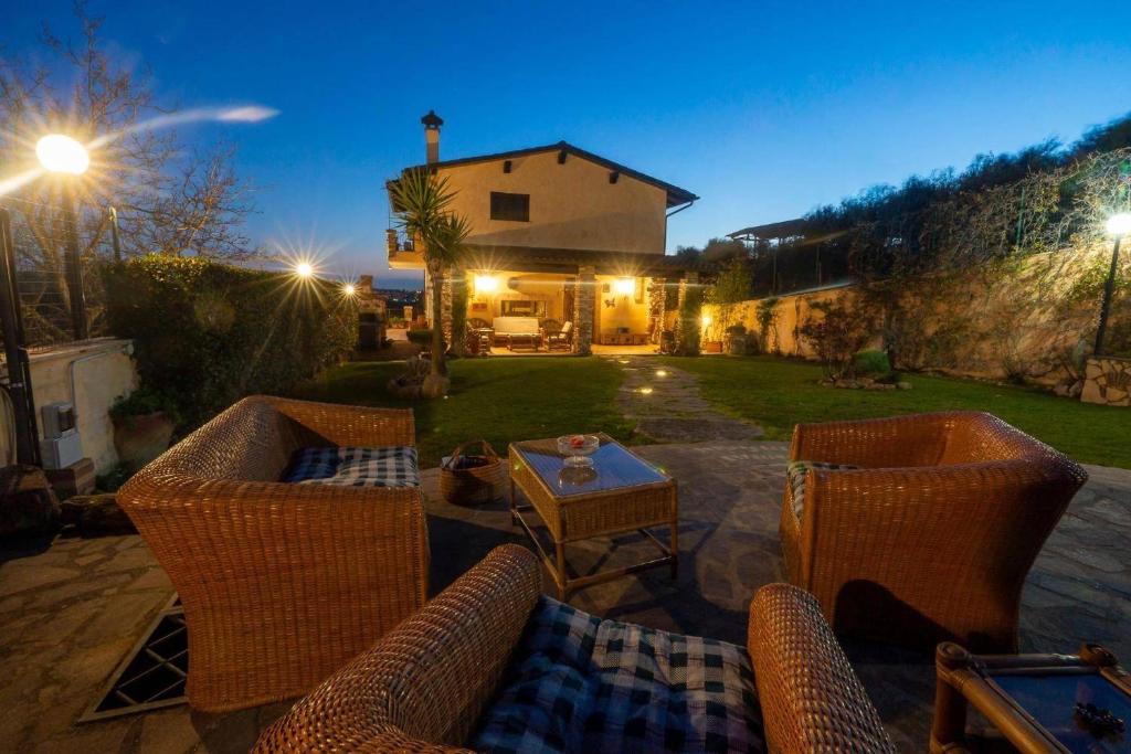 a patio with two wicker chairs and a table at Villa Concipat Rooms in Fonte Nuova