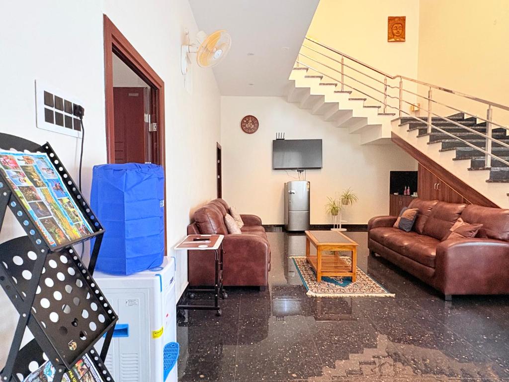 a living room with two couches and a staircase at Yelagiris Honey Stay in Yelagiri