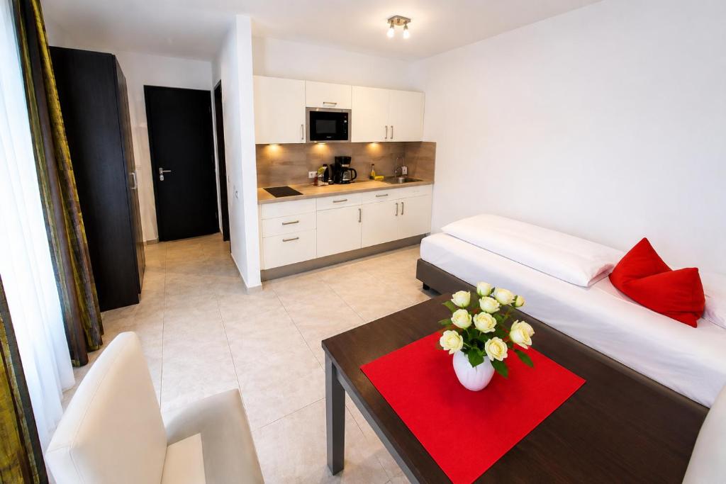 a room with a bed and a table with flowers on it at DuDa Boarding Apartments in Langenbruck