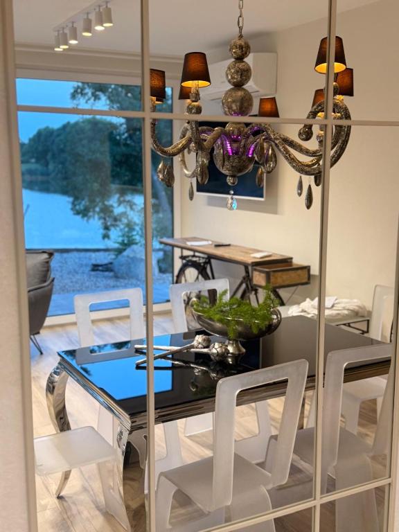 a dining room with a glass table and white chairs at ENKLAWA IMPERIUM- DOM WAKACYJNY-APARTAMENTY NAD JEZIOREM- 20 km od TORUNIA-PLAŻA,JACUZZI 