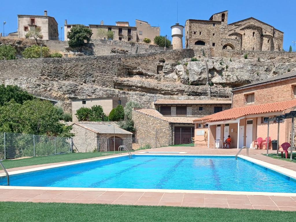 a swimming pool in front of a building with a castle at Casa Potenta in Llimiana