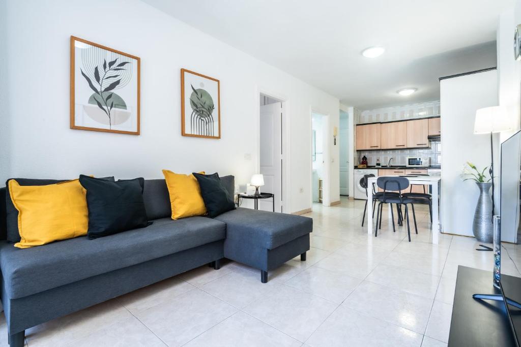a living room with a blue couch and a kitchen at La Posadilla in Adeje
