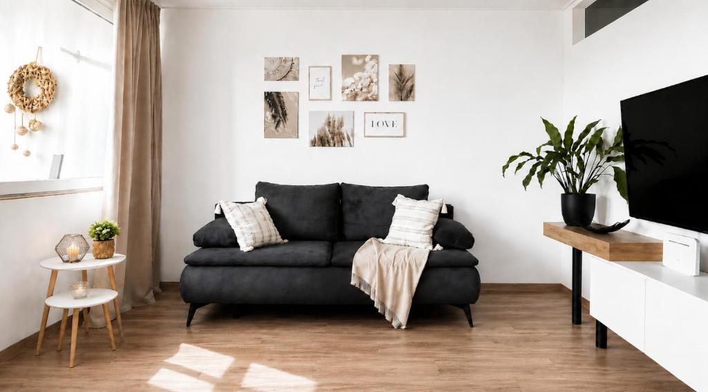 a living room with a black couch and a tv at See- & Bergblick Oberteuringen 59 mit beheiztem Indoor-Pool in Oberteuringen