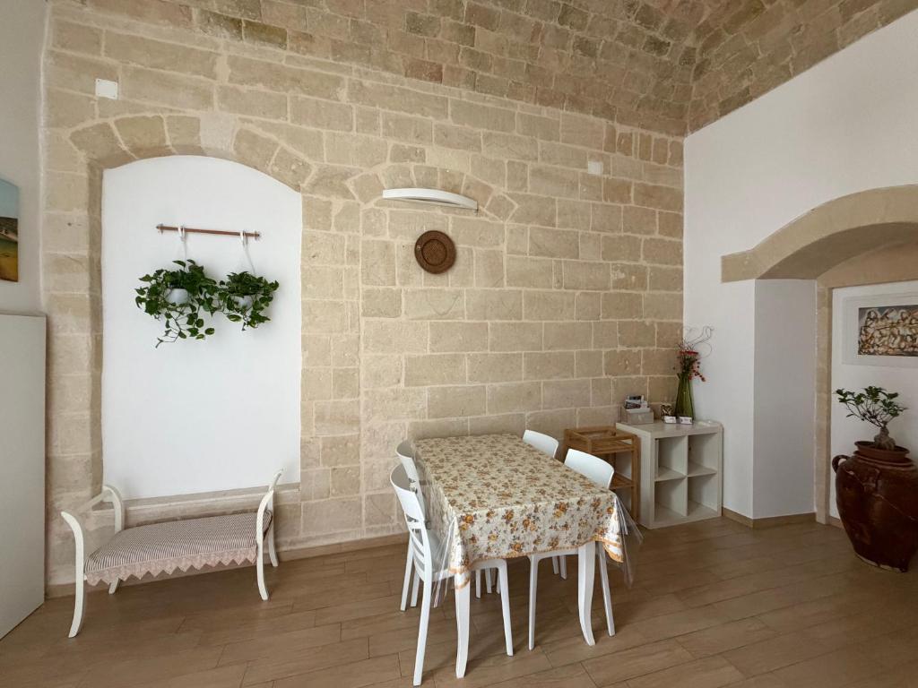 a dining room with a table and chairs and a brick wall at Ai Foggiali in Matera