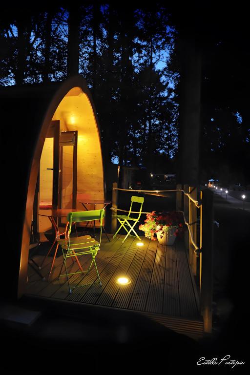 a deck with a table and chairs and a tent at La Cabane Forestière in Voussac
