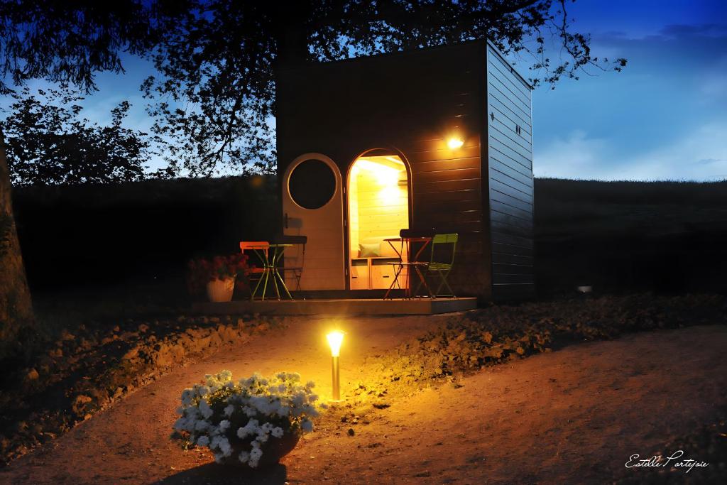 a small cabin with a candle in the yard at night at Cabane Le Carré D'étoiles in Voussac