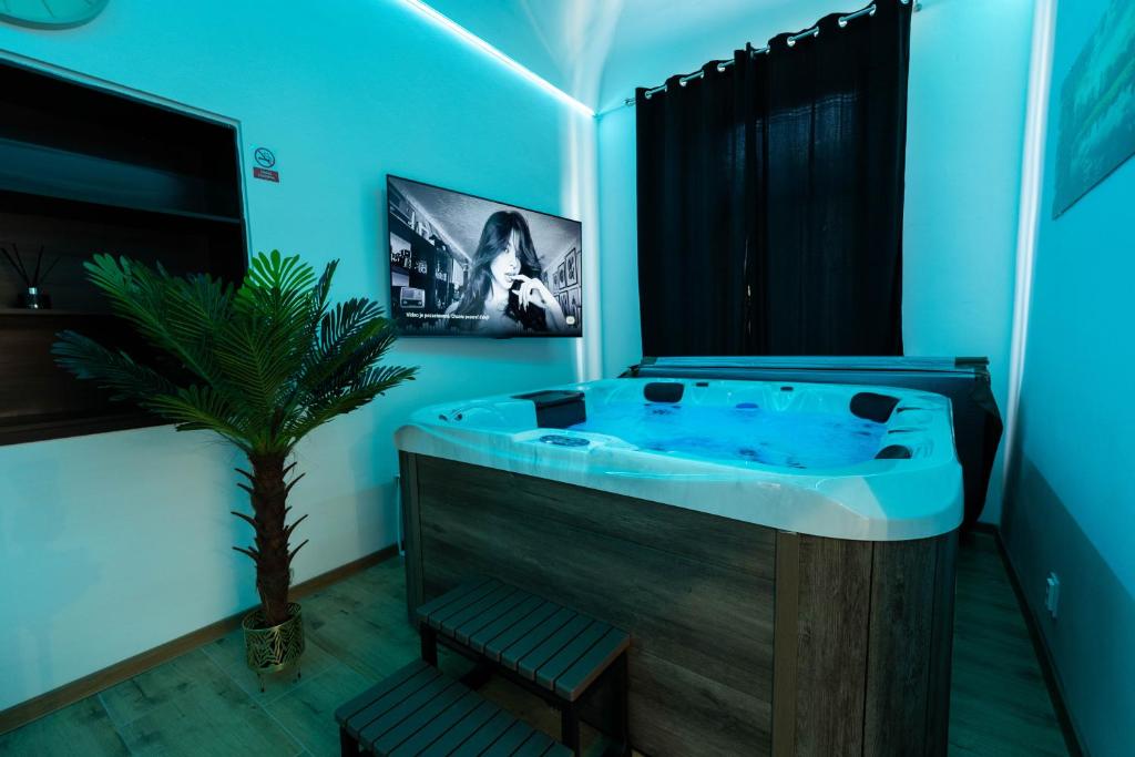 a blue bathroom with a tub with a potted plant at Luxapartment Jacuzzi with Breakfast option in Košice