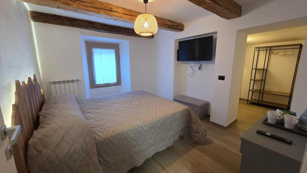 a bedroom with a bed and a flat screen tv at Ca' Mariuccia in Crodo