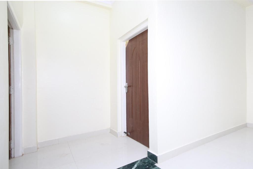a door in a room with white walls at Hotel O Atithi Home Stay in Garhā