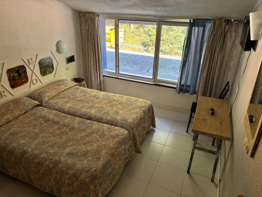 pokój hotelowy z dwoma łóżkami i oknem w obiekcie Hotel Viar w mieście Cabezón de la Sal