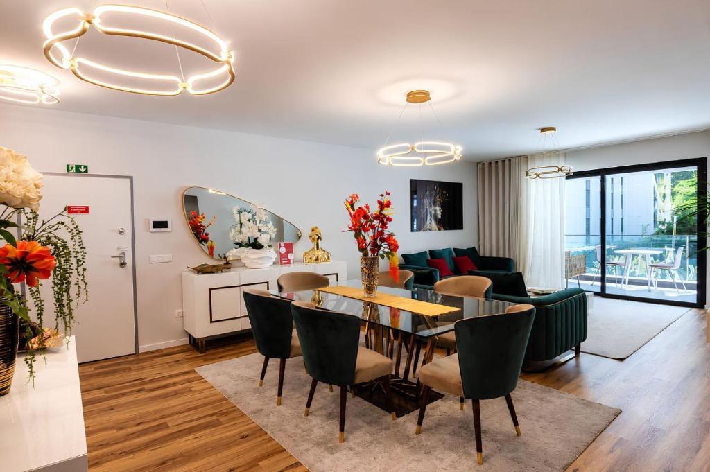 a dining room and living room with a table and chairs at Visconde II F in Ribeira Brava