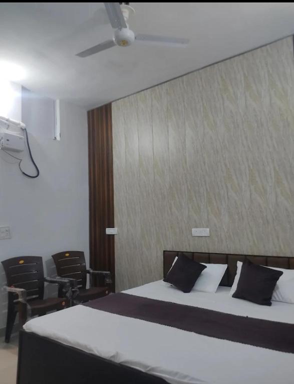 a bedroom with a bed and chairs in a room at Hotel Hidden Gem in Pānīpat
