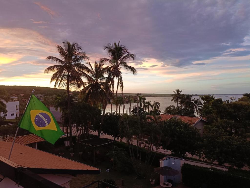a flag is flying in front of palm trees at Rancho do Mirante in Araçatuba