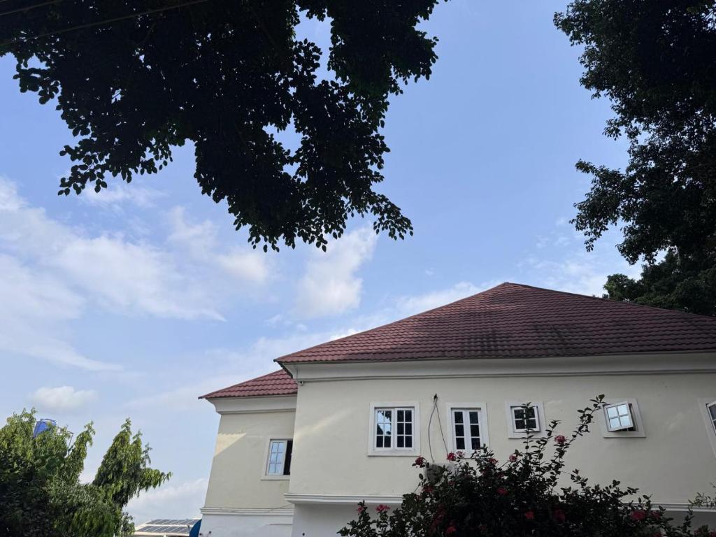 a white house with a red roof at Hotel House 1 in Abuja