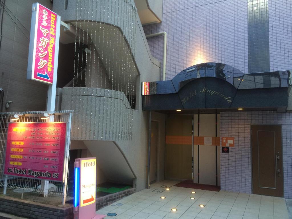 un bâtiment avec un escalier et un panneau en face de celui-ci dans l'établissement Hotel Maganda (Adult Only), à Osaka