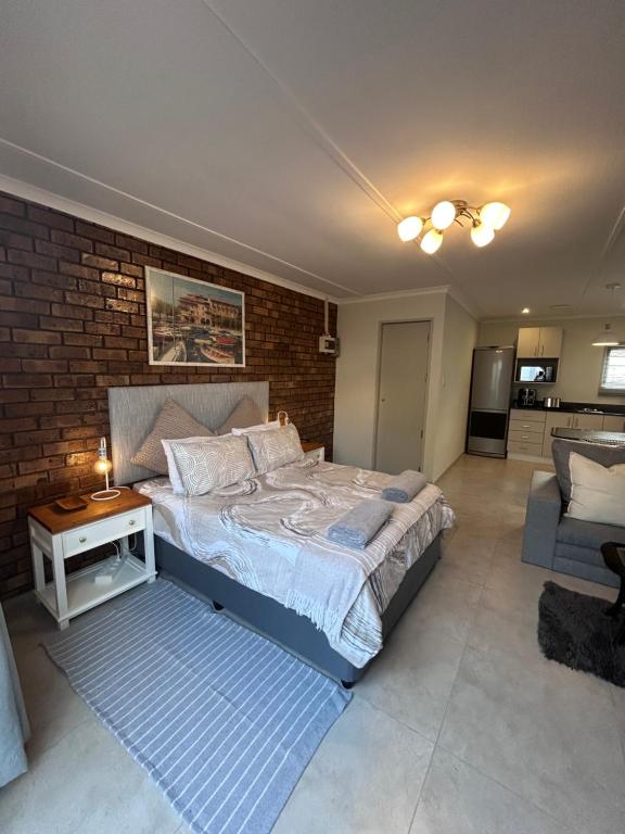 a bedroom with a bed and a brick wall at Whale's Cove in Amanzimtoti