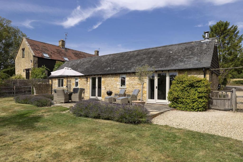 an old stone house with chairs and a patio at Perry Cottage in Halford