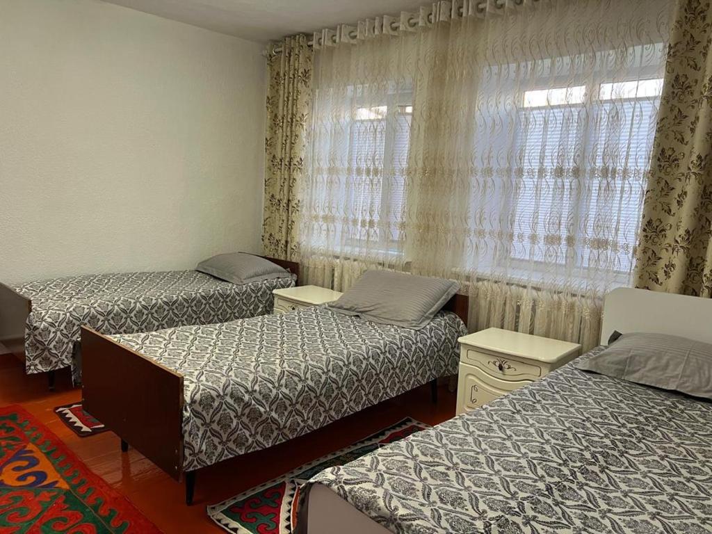 a room with three beds and a window at Guest House Aska Ethno in Kochkorka