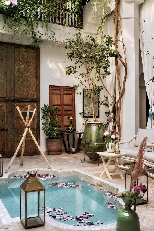 a pool in the middle of a room with plants at Riad Le Coq Berbère in Marrakesh