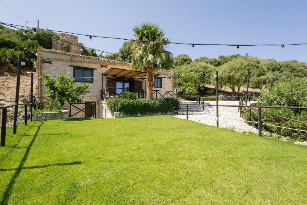 a house with a green lawn in front of it at Mulino 1220 in Scopello