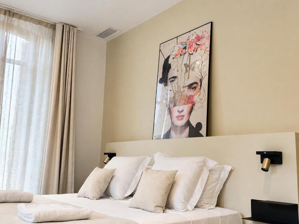 a bedroom with a bed with a painting on the wall at LE PALMIER Aigues-Mortes Petite Camargue in Aigues-Mortes