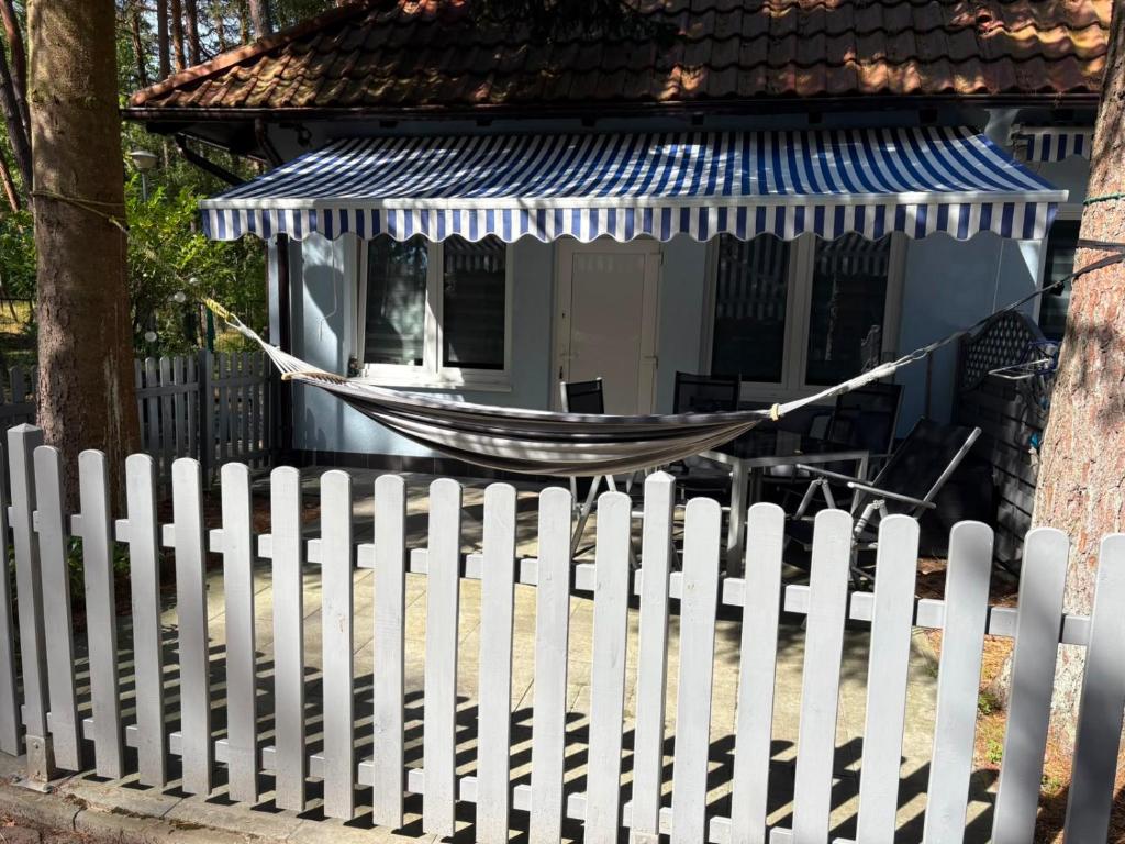 a white fence with a hammock in front of a house at Żagiel 3 in Pobierowo