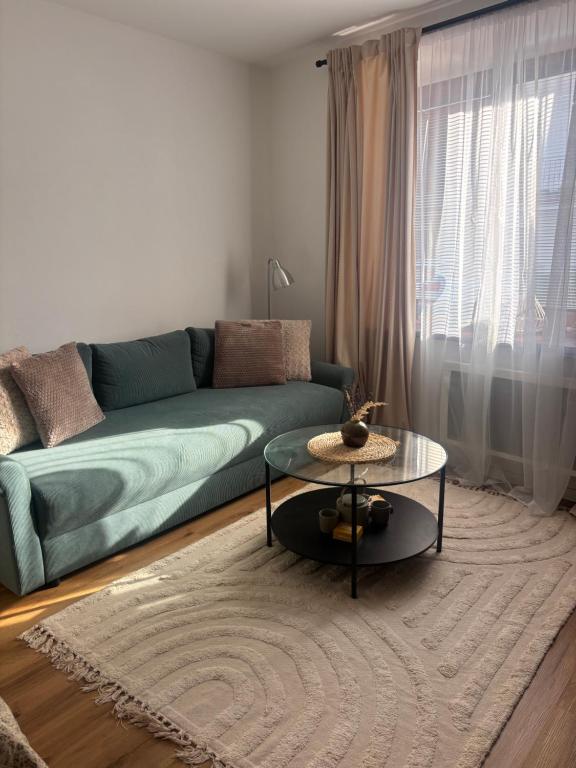 a living room with a green couch and a table at Apartment Ela Centre in Košice