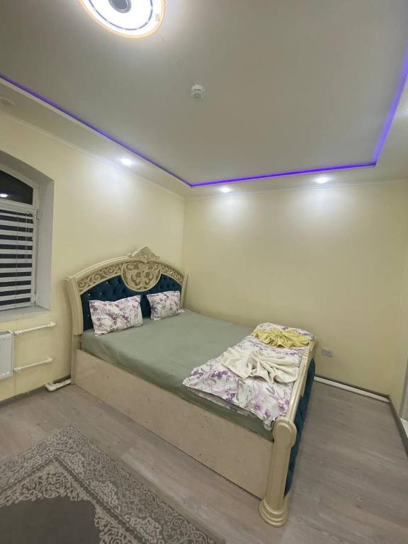 a bedroom with a bed in a room at Qoya in Fergana
