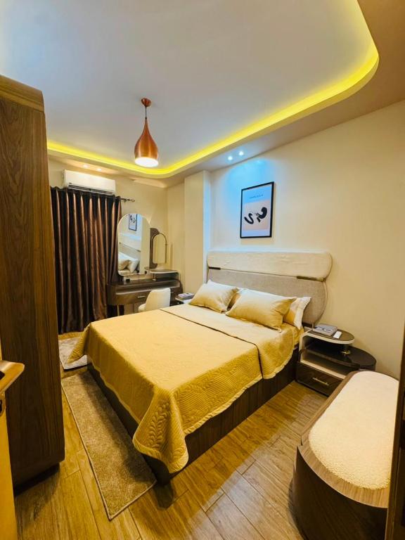a bedroom with a large bed and a desk at XOtel in Dumyāţ al Jadīdah